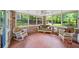 Bright sunroom filled with natural light, brick walls, mosaic tile floor and wicker furniture at 2179 Mountclaire Ct, Stone Mountain, GA 30087