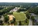 Aerial shot of the community park featuring a large green space, a playground, and lush landscaping with walking trails at 420 Gold Xing, Canton, GA 30114
