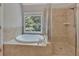 Bright bathroom featuring a soaking tub next to a window and glass-enclosed shower at 420 Gold Xing, Canton, GA 30114