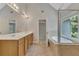 Bright bathroom featuring a soaking tub next to a window and double vanity sinks with tile flooring at 420 Gold Xing, Canton, GA 30114