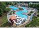 An aerial view shows a fantastic community pool with a waterslide, a shallow area, and an abundance of seating at 420 Gold Xing, Canton, GA 30114