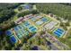 An aerial shot showcasing multiple well-maintained tennis courts surrounded by lush greenery and ample parking at 420 Gold Xing, Canton, GA 30114