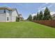 Large grassy backyard featuring trees, a fence and the home's exterior at 4315 Balsam Bark Dr, Cumming, GA 30028
