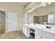 A bathroom with double vanities, a large mirror, and a glass-enclosed shower at 4315 Balsam Bark Dr, Cumming, GA 30028
