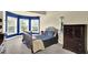 Bedroom with bay windows, blue accent wall, carpet and dark wood furniture at 4315 Balsam Bark Dr, Cumming, GA 30028
