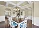 Bright dining room with coffered ceilings, chandelier, and modern white wainscoting and trim at 4315 Balsam Bark Dr, Cumming, GA 30028