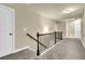 Spacious upstairs hallway with carpet, a wooden handrail, and three doors at 4315 Balsam Bark Dr, Cumming, GA 30028