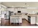 Kitchen featuring stainless steel appliances, granite countertops, a central island with seating and wood floors at 4315 Balsam Bark Dr, Cumming, GA 30028