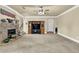 Spacious living room featuring a stone fireplace, television, staircase, and ceiling fan at 4315 Balsam Bark Dr, Cumming, GA 30028