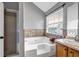 Well-lit bathroom featuring a soaking tub with tile surround, a walk-in shower and a wooden vanity at 5485 Shirewick Ln, Lithonia, GA 30058