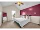 This bedroom features soft cream walls, a plum accent wall, and a comfortable queen size bed at 5485 Shirewick Ln, Lithonia, GA 30058