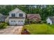 Charming two-story home with a well-manicured lawn, two-car garage and manicured yard with mature trees at 5485 Shirewick Ln, Lithonia, GA 30058