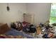 Cluttered bedroom showing a bed, window, and dresser in disrepair at 590 Killian Rd, Canton, GA 30114