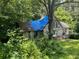 A-frame home sitting on a wooded lot and covered by a blue tarp at 590 Killian Road Rd, Canton, GA 30114