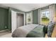 Bright bedroom with lush green walls features a large window and walk-in closet at 221 Paisley Way, Locust Grove, GA 30248