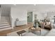 Open-concept living room with stairs, decor, and access to the kitchen and dining area at 221 Paisley Way, Locust Grove, GA 30248