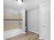 Updated bathroom featuring a tub, shower with tile surround, and wood-look flooring at 4720 Hull Rd, Conyers, GA 30094