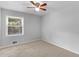 A gray bedroom featuring carpet flooring and a large window for natural light at 4720 Hull Rd, Conyers, GA 30094
