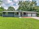 Single-story home featuring a two-car garage, front porch and mature trees in a vibrant, green front yard at 4720 Hull Rd, Conyers, GA 30094
