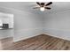 Spacious living room with wood floors, neutral paint and trim, base molding and a view into the modern kitchen at 4720 Hull Rd, Conyers, GA 30094