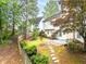 Secluded backyard featuring a stone walkway, patio, and lush landscaping, perfect for outdoor relaxation at 3229 Dunlin Lake Rd, Lawrenceville, GA 30044