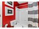 A full bathroom featuring red walls, a white tiled shower with striped curtain, and art at 3229 Dunlin Lake Rd, Lawrenceville, GA 30044