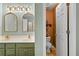Bright bathroom featuring a double sink vanity, gold fixtures, a separate toilet room, and green cabinetry at 3229 Dunlin Lake Rd, Lawrenceville, GA 30044