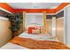 Cozy bedroom featuring a bed with orange accents, an indoor tree, and a neutral color scheme at 3229 Dunlin Lake Rd, Lawrenceville, GA 30044
