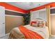 Bedroom with an orange accent wall, large window, decorative indoor tree and comfortable bed at 3229 Dunlin Lake Rd, Lawrenceville, GA 30044
