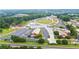 Aerial view of a park featuring walking paths, water features, an amphitheater, a church, and parking lots at 4130 Stonecypher Rd, Suwanee, GA 30024