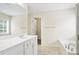 Bright bathroom featuring a dual sink vanity, soaking tub, and a view to the walk-in closet at 4130 Stonecypher Rd, Suwanee, GA 30024