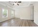 Bright bedroom with generous natural light, tray ceiling, ceiling fan, and wood-look flooring at 4130 Stonecypher Rd, Suwanee, GA 30024