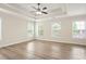 Large bedroom with recessed ceilings, ceiling fan, and multiple windows with views to the outdoors at 4130 Stonecypher Rd, Suwanee, GA 30024