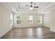 Well-lit bedroom with trey ceilings, ceiling fan, generous windows, and stylish wood-look floors at 4130 Stonecypher Rd, Suwanee, GA 30024