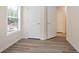 Bright room with modern floors, window, and access to closet spaces and hallway at 4130 Stonecypher Rd, Suwanee, GA 30024