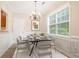 Elegant dining room with crown molding, wainscoting, modern chandelier, and a large window at 4130 Stonecypher Rd, Suwanee, GA 30024