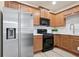 Modern kitchen showcasing stainless steel refrigerator, gas range, microwave, and sleek countertops at 4130 Stonecypher Rd, Suwanee, GA 30024
