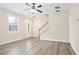Open-concept living area with luxury flooring, a staircase, and ample natural light at 4130 Stonecypher Rd, Suwanee, GA 30024