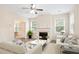 Bright living room featuring a fireplace, large windows, neutral tones, and modern ceiling fan at 4130 Stonecypher Rd, Suwanee, GA 30024