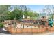Large wooden playground structure with swings, slides, and climbing areas, surrounded by a fence at 4130 Stonecypher Rd, Suwanee, GA 30024
