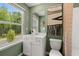 Green bathroom with a white vanity, a view of the backyard, and a window at 229 Paisley Way, Locust Grove, GA 30248