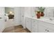 Bright bathroom showcasing double vanity, white cabinets, and a doorway leading to the bedroom at 229 Paisley Way, Locust Grove, GA 30248