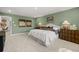 Well-lit main bedroom featuring soft green walls, carpet floors, and stylish furnishings at 229 Paisley Way, Locust Grove, GA 30248