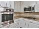 Close up shot of stainless steel oven, cooktop, countertops, and white cabinets at 3357 Huntwood Ct, Decatur, GA 30034