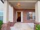 Inviting covered front porch with brick accents and a view into the foyer at 3429 Lake End Dr, Loganville, GA 30052