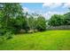 A lush backyard with a grassy lawn, privacy fence, and mature trees at 5279 Leecroft Dr, Buford, GA 30518