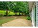 A backyard featuring a patio, green grass, and lush green trees at 5279 Leecroft Dr, Buford, GA 30518