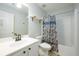 Clean bathroom with white vanity, toilet, bathtub and shower featuring neutral-patterned shower curtain at 5279 Leecroft Dr, Buford, GA 30518
