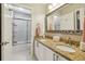 Bright bathroom featuring a double vanity with granite countertops and a glass-enclosed shower at 335 Scarborough Way, Alpharetta, GA 30022