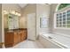 Well-lit bathroom featuring a soaking tub, double vanity, and natural light at 335 Scarborough Way, Alpharetta, GA 30022